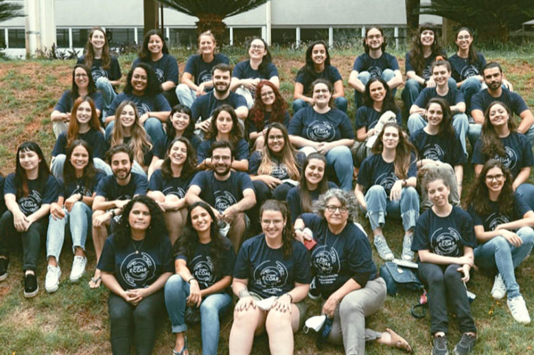 Dezenas de profissionais do Projeto Ecoar sentados em um gramado